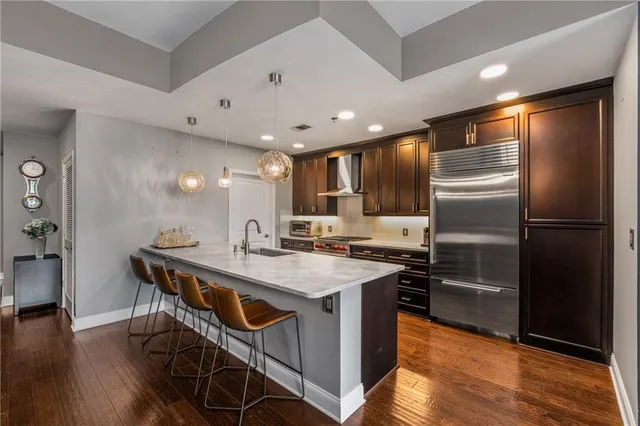 a kitchen with stainless steel appliances granite countertop a refrigerator a sink and a stove