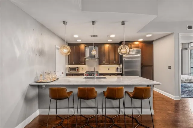 a kitchen with stainless steel appliances kitchen island granite countertop a kitchen island and chairs in it
