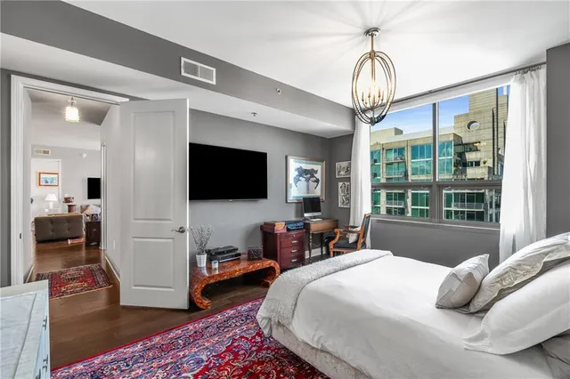 a bedroom with a bed and a flat tv screen on the dresser