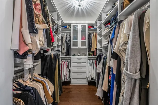 a view of walk in closet with clothes and shoes