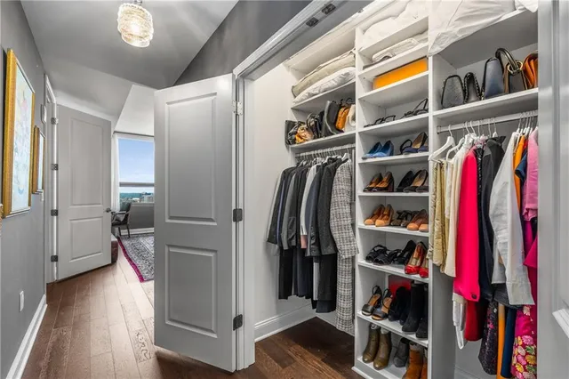 a view of walk in closet with clothes and shoes