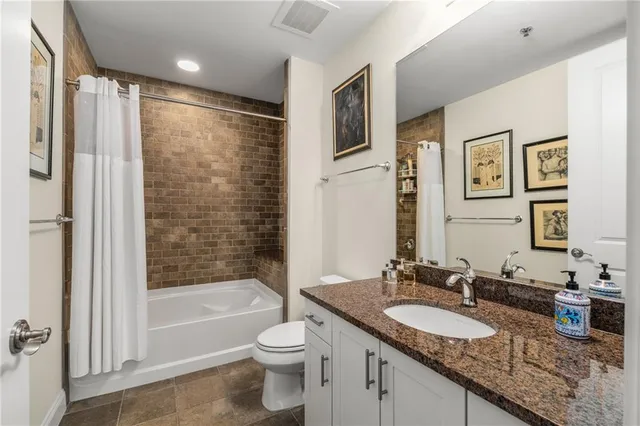 a bathroom with a granite countertop sink toilet and shower
