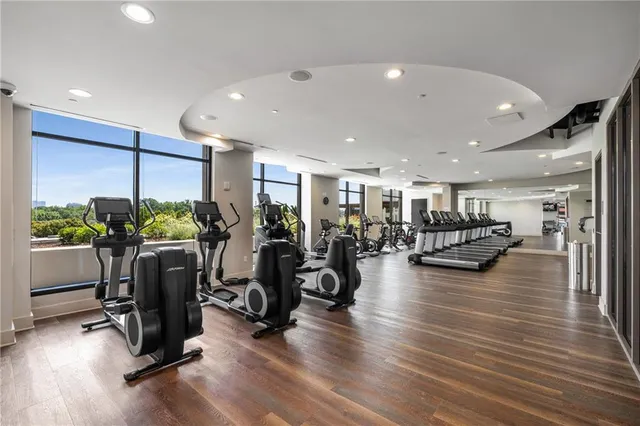 a view of a room with gym equipment and wooden floor