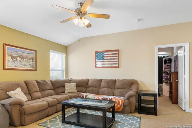 a living room with furniture a ceiling fan and a window