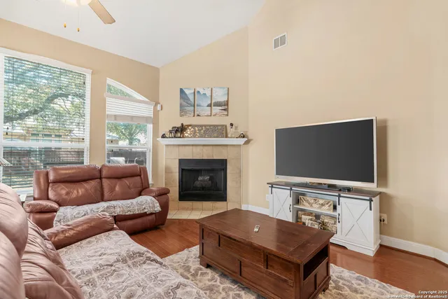 a living room with furniture a flat screen tv and a fireplace