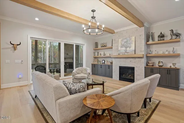 a living room with furniture a fireplace and a chandelier