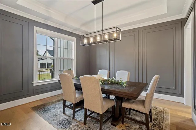 a dining room with furniture a chandelier and wooden floor