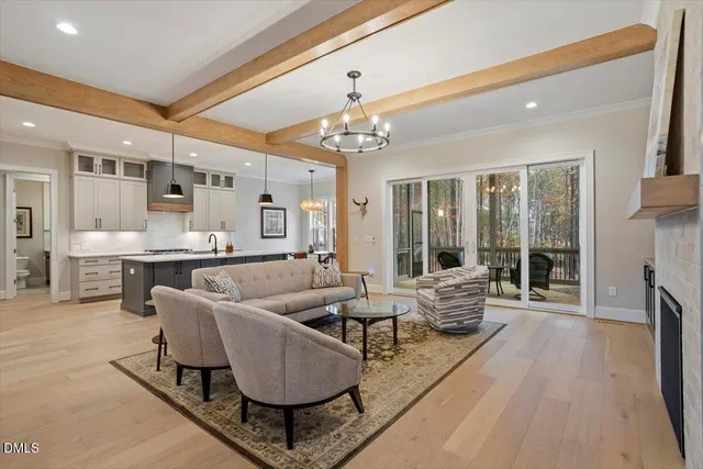 a living room with furniture a fireplace and a chandelier