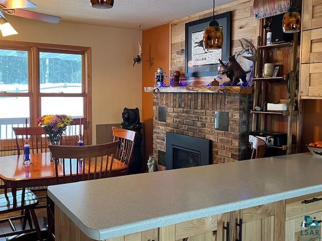 1775 Maple Street Ely, MN 55731 - Photo 3 of 18 Kitchen featuring hanging light fixtures, a textured ceiling, and a fireplace