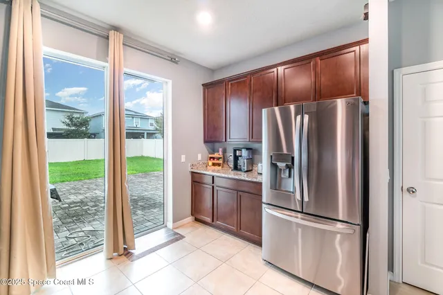 a metallic refrigerator freezer sitting inside of a kitchen