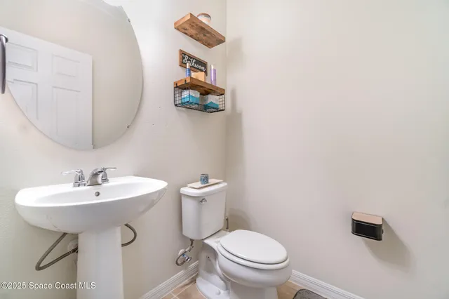 a bathroom with a sink toilet and a mirror