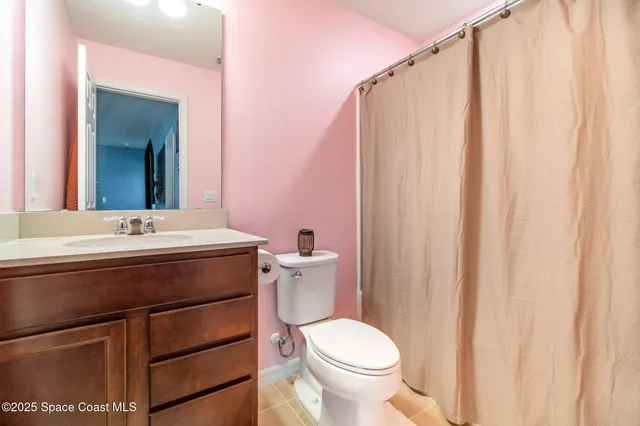 a bathroom with a sink a toilet and shower curtain