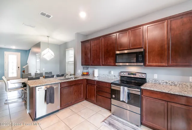 a kitchen with stainless steel appliances granite countertop wooden cabinets and a stove top oven