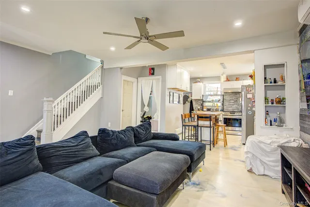a living room with furniture ceiling fan and a rug