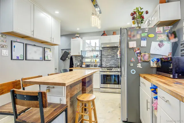 a kitchen that has a lot of cabinets in it and wooden floors