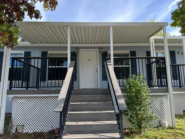 a backyard of a house with a table and chairs