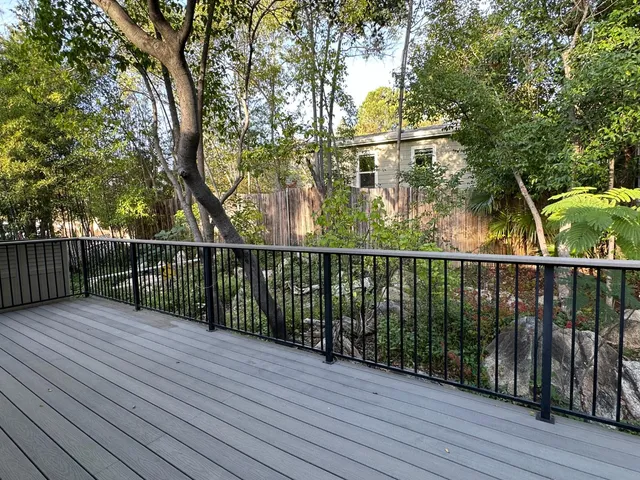 a view of a backyard with a large window and wooden fence