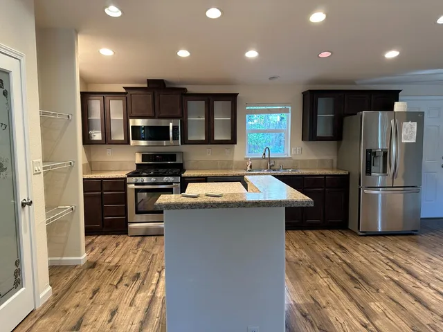 a kitchen with stainless steel appliances granite countertop a sink stove and cabinets