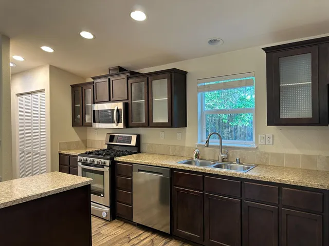 a kitchen with stainless steel appliances granite countertop a stove microwave and cabinets