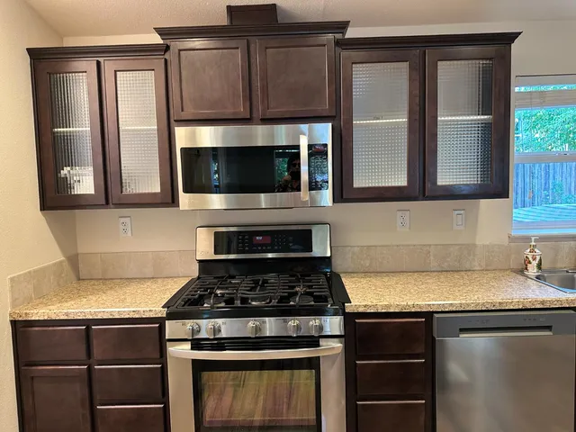 a room with granite countertop cabinets and wooden floor