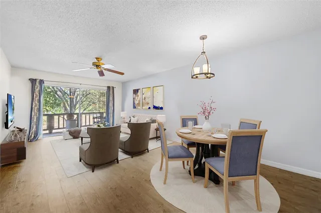 a view of a dining room with furniture a chandelier and wooden floor