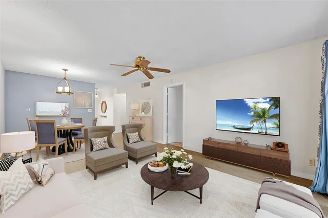 a living room with furniture and a ceiling fan