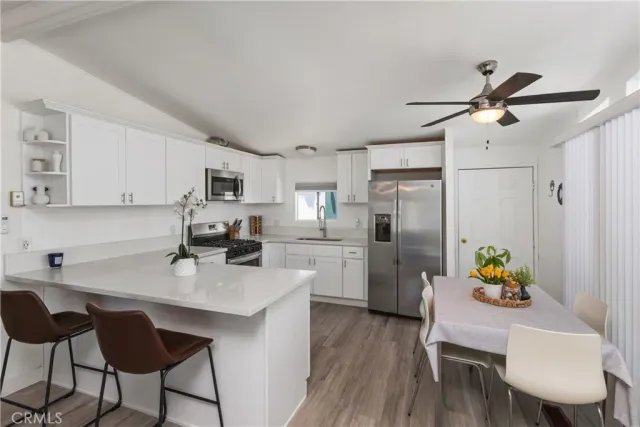 a kitchen with a dining table chairs refrigerator and microwave