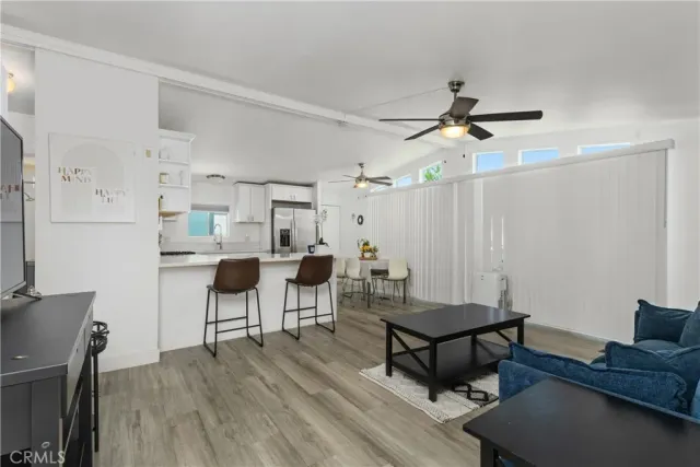 a living room with furniture a flat screen tv and a window