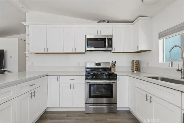 a kitchen with white cabinets and stainless steel appliances