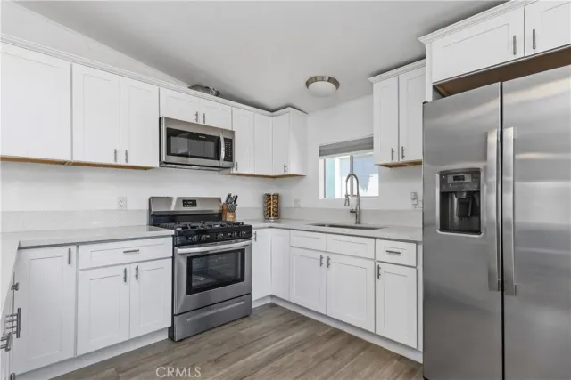 a kitchen with cabinets stainless steel appliances and a sink