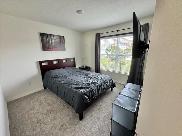 a bedroom with a bed lamp and a window
