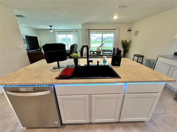 a kitchen with kitchen island a stove a sink a dining table and chairs