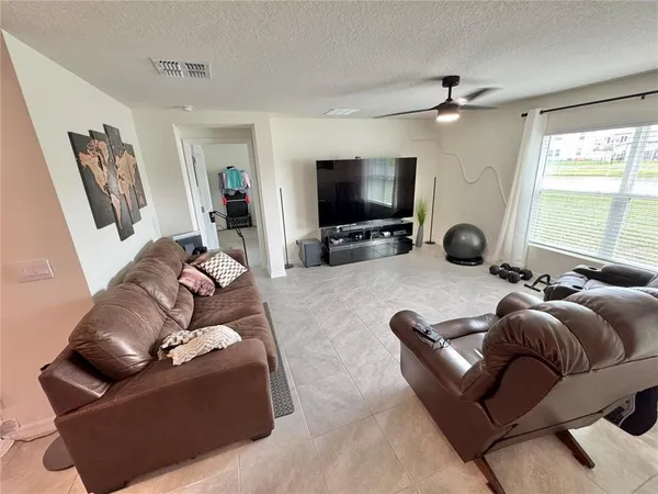 a living room with furniture a flat screen tv and a large window