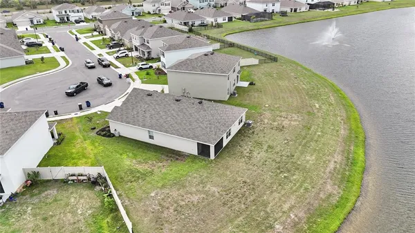 an aerial view of a house with a garden and lake view