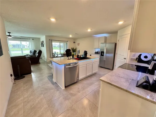a view of a kitchen with refrigerator and furniture