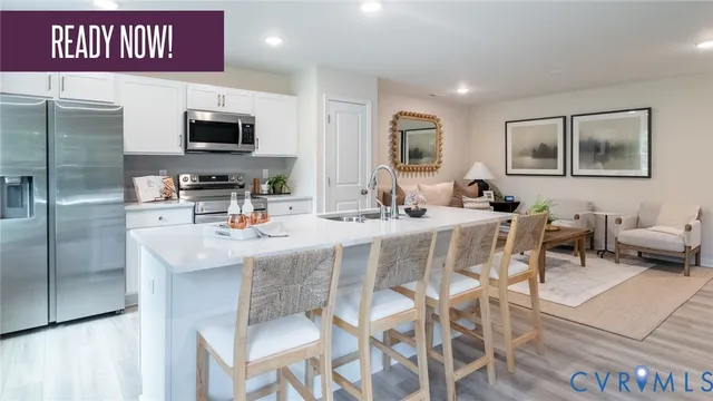 a kitchen with stainless steel appliances kitchen island granite countertop a table and chairs in it