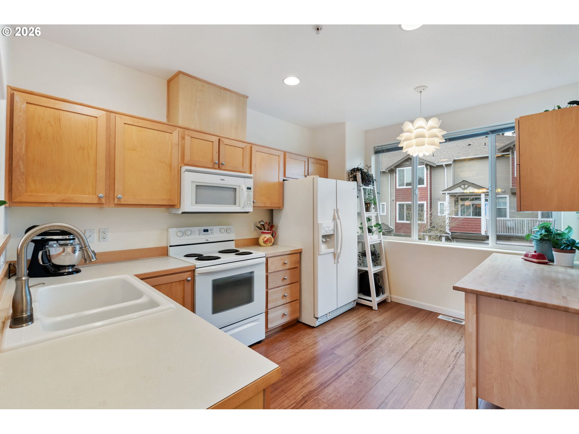15465 Southwest Sparrow Loop, Unit 102 Beaverton, OR 97007 - Photo 11 of 44 a kitchen with a refrigerator sink and wooden cabinets