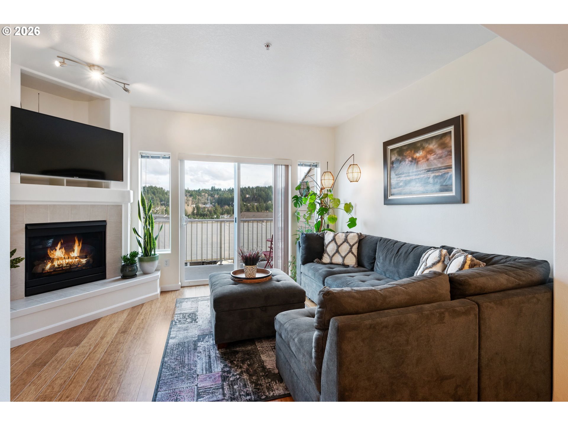 15465 Southwest Sparrow Loop, Unit 102 Beaverton, OR 97007 - Photo 5 of 44 a living room with furniture a flat screen tv and a fireplace