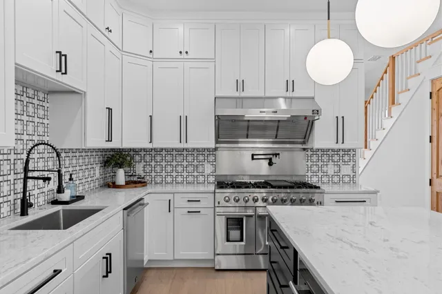 a view of kitchen and kitchen with stainless steel appliances wooden floor
