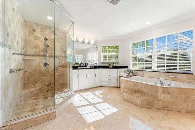 a spacious bathroom with a large tub shower and windows