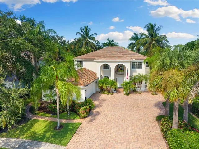 a front view of a house with a yard and potted plants