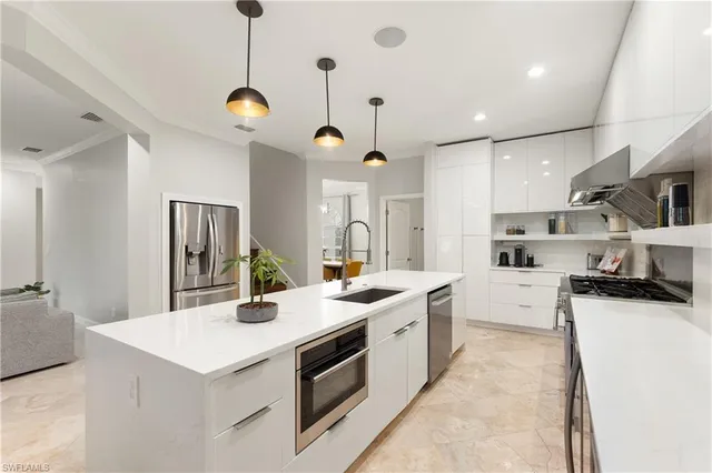 a kitchen with stainless steel appliances kitchen island a sink stove and refrigerator