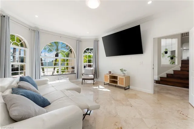 a living room with furniture a flat screen tv and a large window