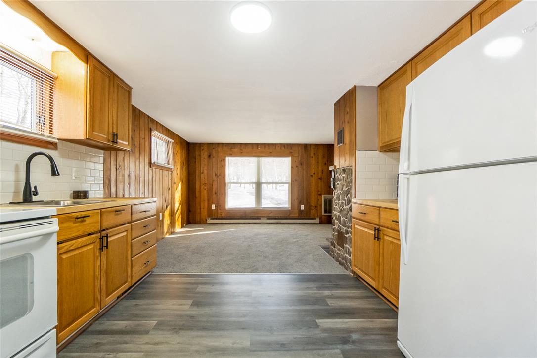 121 Short Ridge Road Albrightsville, PA 18210 - Photo 21 of 35 Rich wood paneling and stone accents frame this inviting open-concept kitchen and living area.