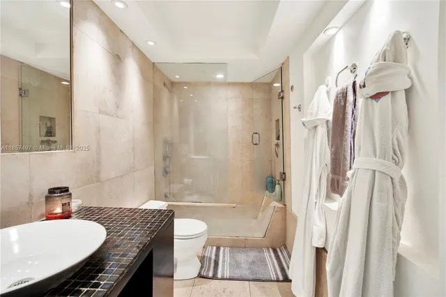 a bathroom with a granite countertop sink a mirror a toilet and a bathtub