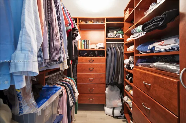 a view of walk in closet with clothes and shoes