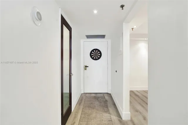 a view of a hallway to a room with front door