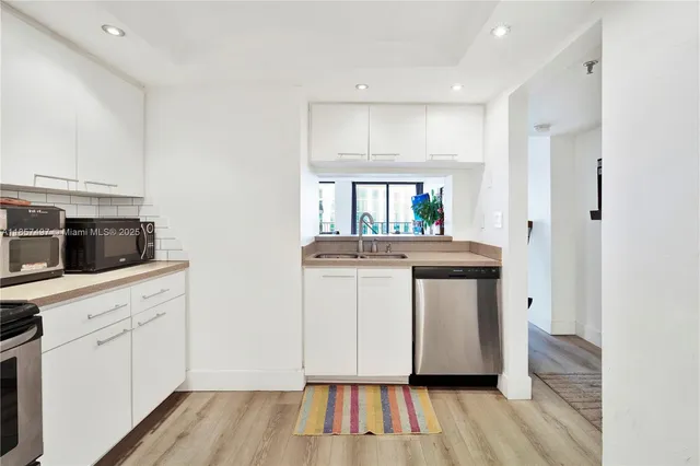 a kitchen with a sink cabinets and wooden floor