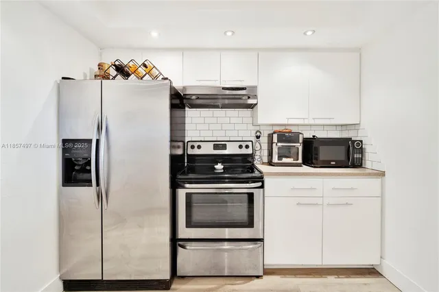 a kitchen with stainless steel appliances a stove a microwave and a refrigerator