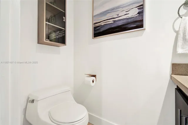 a white toilet sitting next to a white wall